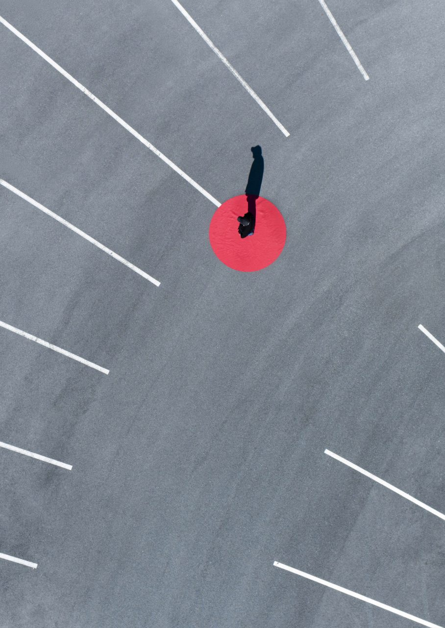 Photo aérienne graphique et créative par drone d'un homme debout sur un cercle rouge.